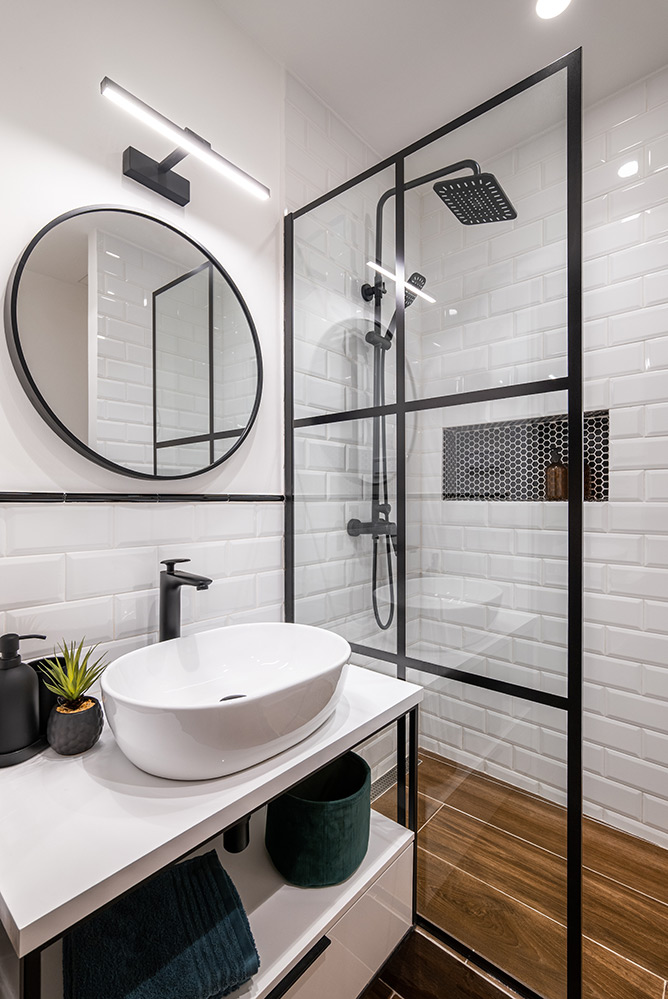 Modern sink and shower in white tiled bathroom